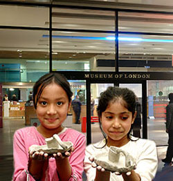 A photograph of children showing of the pottery that they have made. Follow this link to the Museum of London website